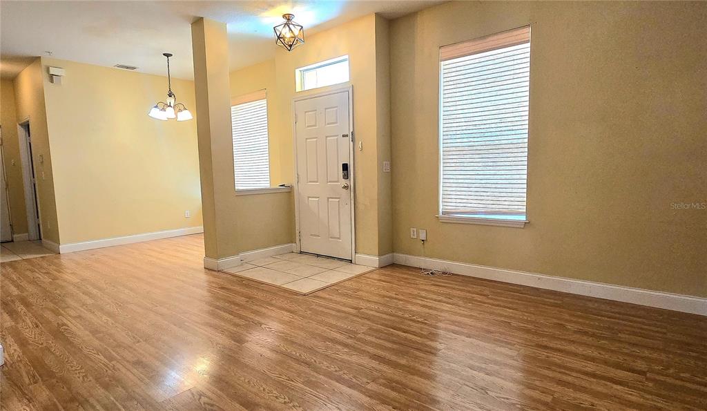 An entryway with wood-look flooring, a white front door, and a large window with blinds — 2921 PINE OAK TRAIL, SANFORD, FL