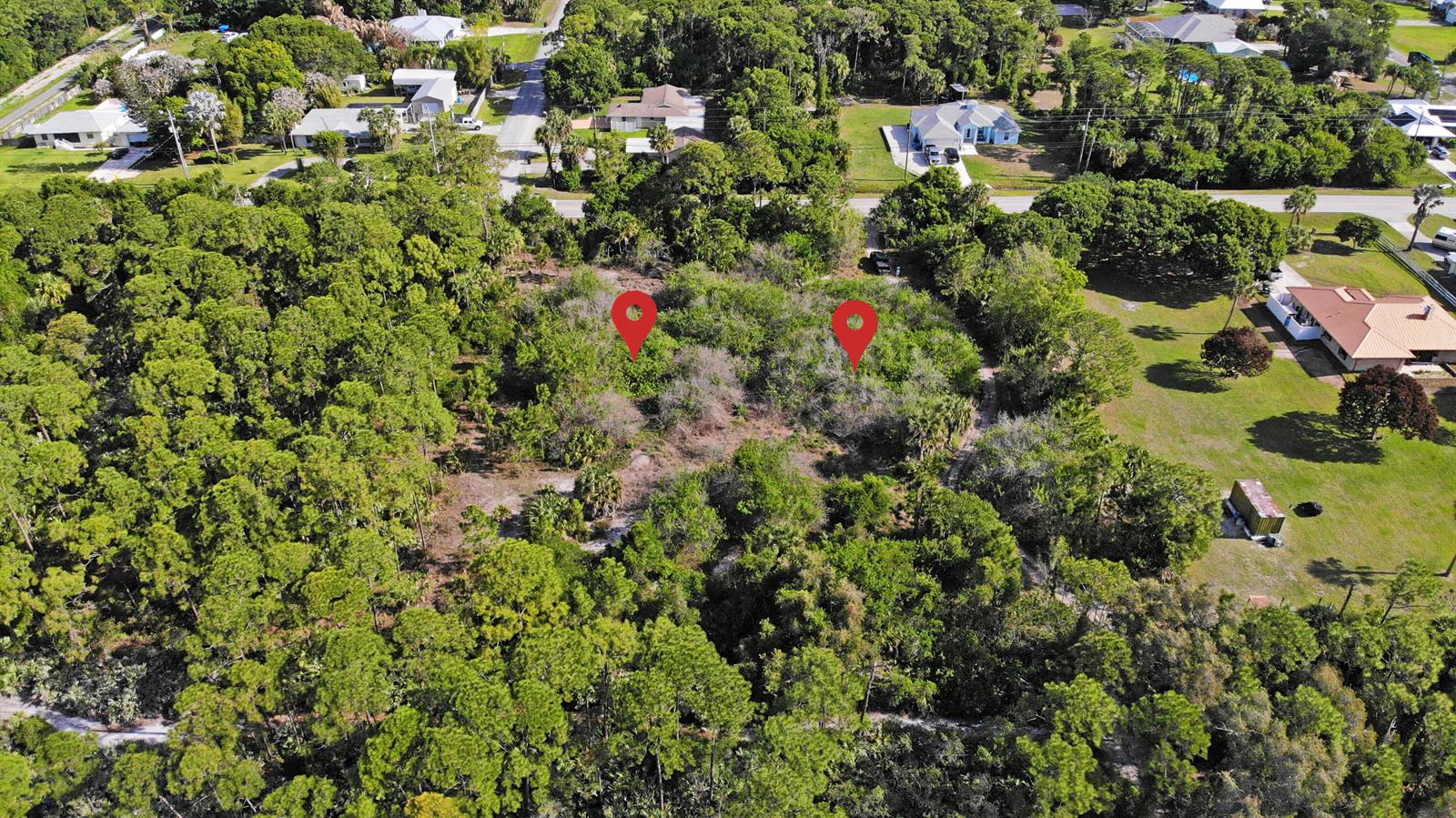 An aerial view shows a wooded, undeveloped lot with two red location pins — (0001) E Easy Street, Fort Pierce FL 34982, FORT PIERCE, FL