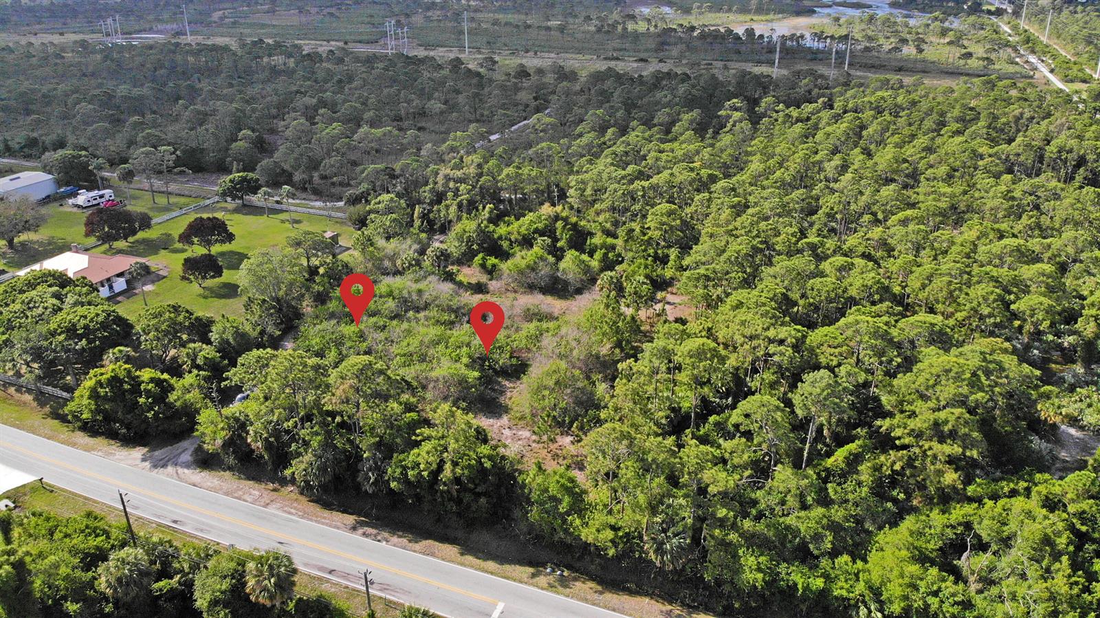 An aerial view shows a wooded lot with two red location pins near a road — (0001) E Easy Street, Fort Pierce FL 34982, FORT PIERCE, FL