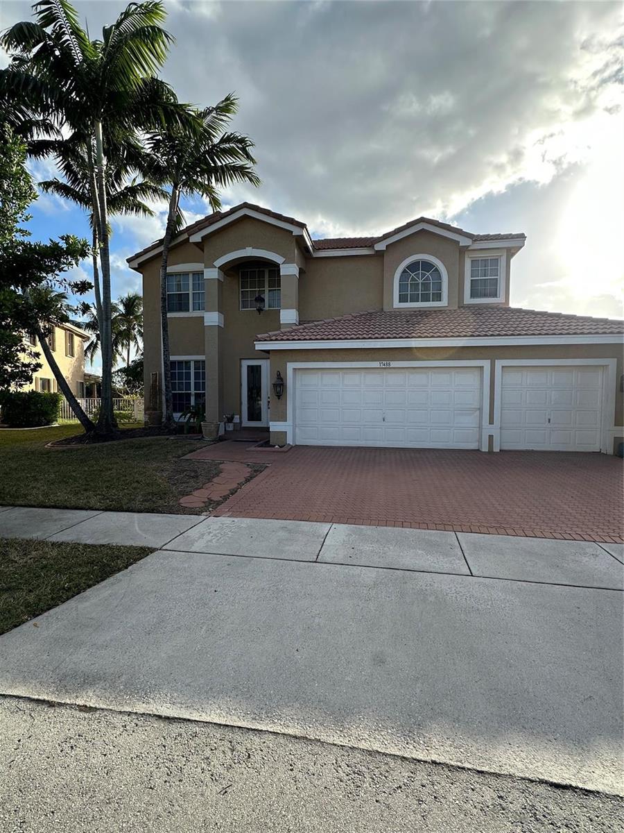 A two-story suburban house features a tan stucco exterior, a tiled roof, and a three-car garage — 17488 SW 36th Street, Miramar FL 33029, MIRAMAR, FL