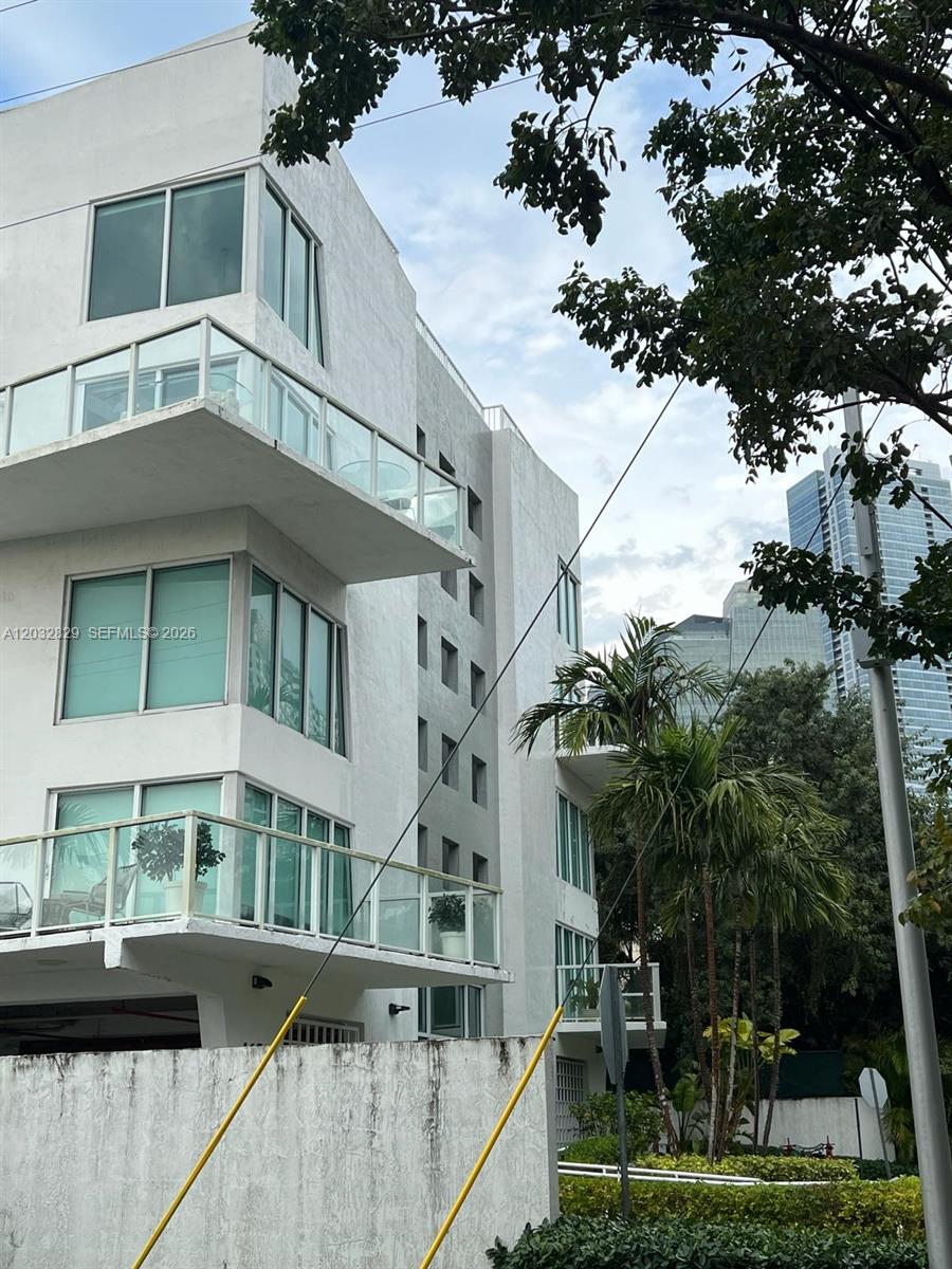 A multi-story white residential building features glass-railed balconies and large windows — 1650 Brickell Ave # 206, Miami FL 33129, MIAMI, FL