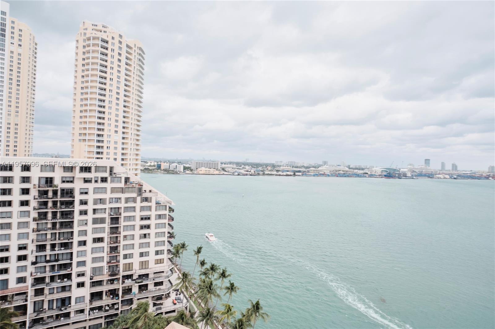 An open-concept living area features polished tile floors, a modern chandelier, and floor-to-ceiling windows — 520 Brickell Key Dr # A1904, Miami FL 33131, MIAMI, FL