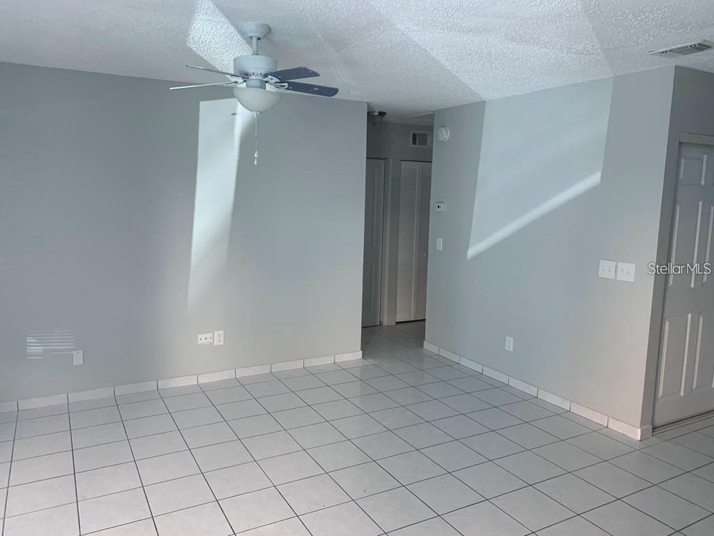 A room with light gray walls, white tile flooring, and a ceiling fan — 49 LAS BRISAS COURT, KISSIMMEE, FL