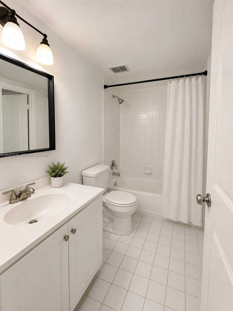 A bathroom features a white vanity, a toilet, and a shower-tub combination with white tiles — 6886 N Kendall Dr # D407, Pinecrest FL 33156, PINECREST, FL