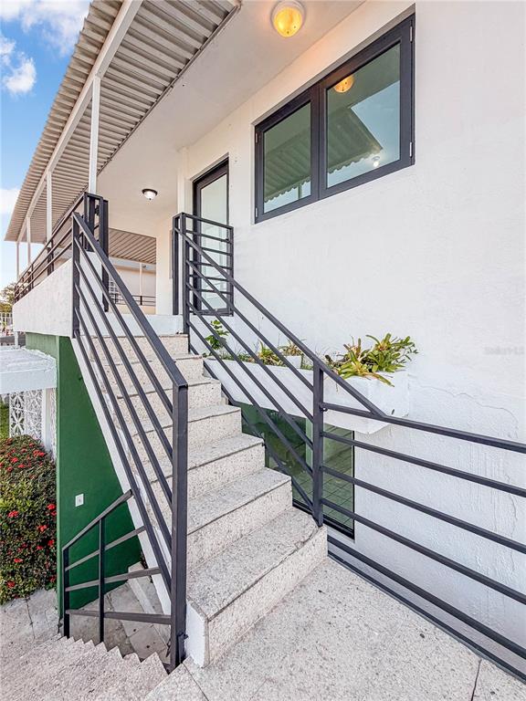 An outdoor staircase with metal railings leads to an elevated entrance of a white building — 234 234 UNIT HH16 - B, CAROLINA, PR