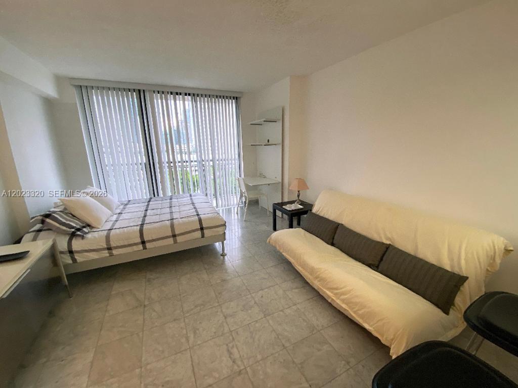 This studio apartment features a bed, a sofa, a desk, and tile flooring — 540 Brickell Key Dr # 913, Miami FL 33131, MIAMI, FL