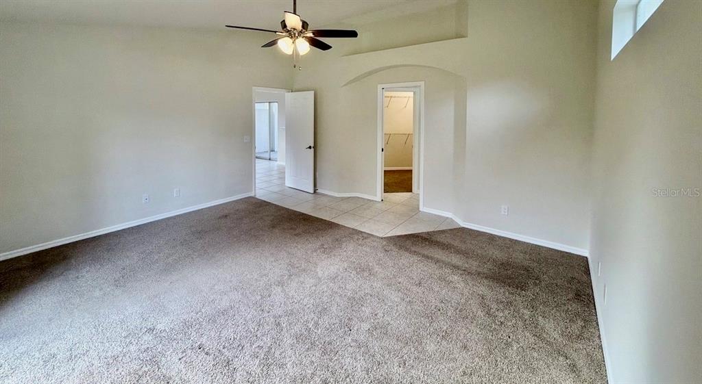 A bedroom with carpeted flooring, a ceiling fan, and two doorways leading to other rooms — 229 VENICE PALMS BOULEVARD, VENICE, FL