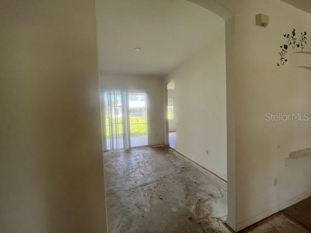An interior view of a room with bare concrete floors and a sliding glass door — 5566 LAVENDER AVENUE, NORTH PORT, FL
