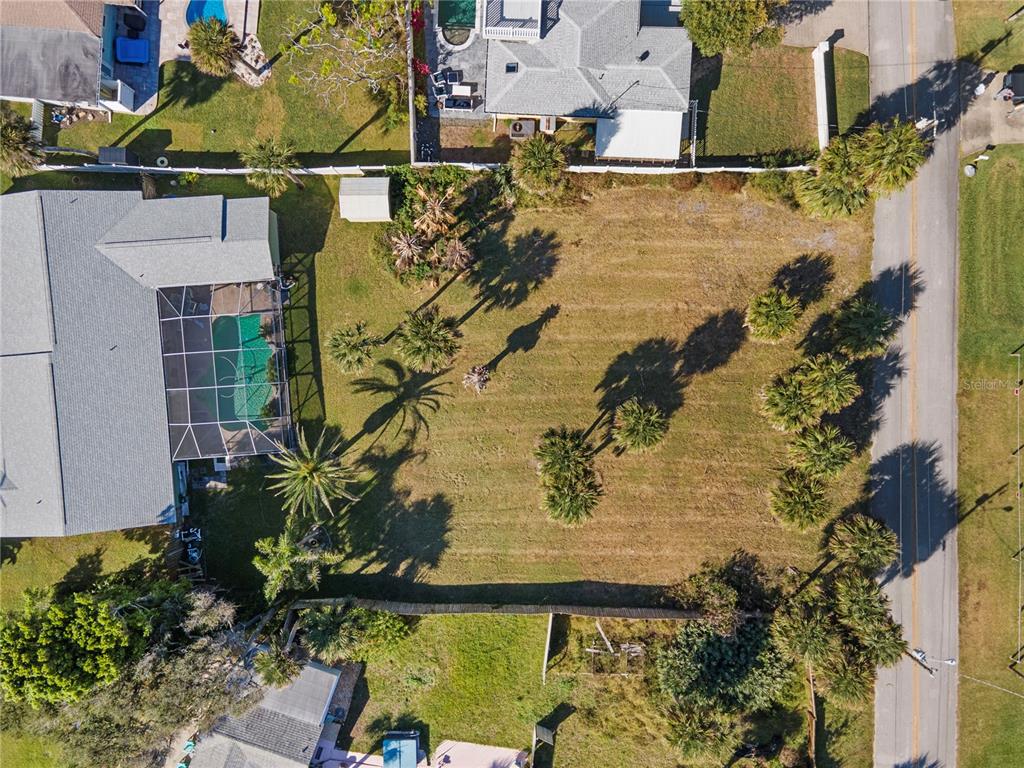 An aerial view shows a vacant residential lot situated between two houses with pools — 4216 CARDINAL BOULEVARD, PORT ORANGE, FL