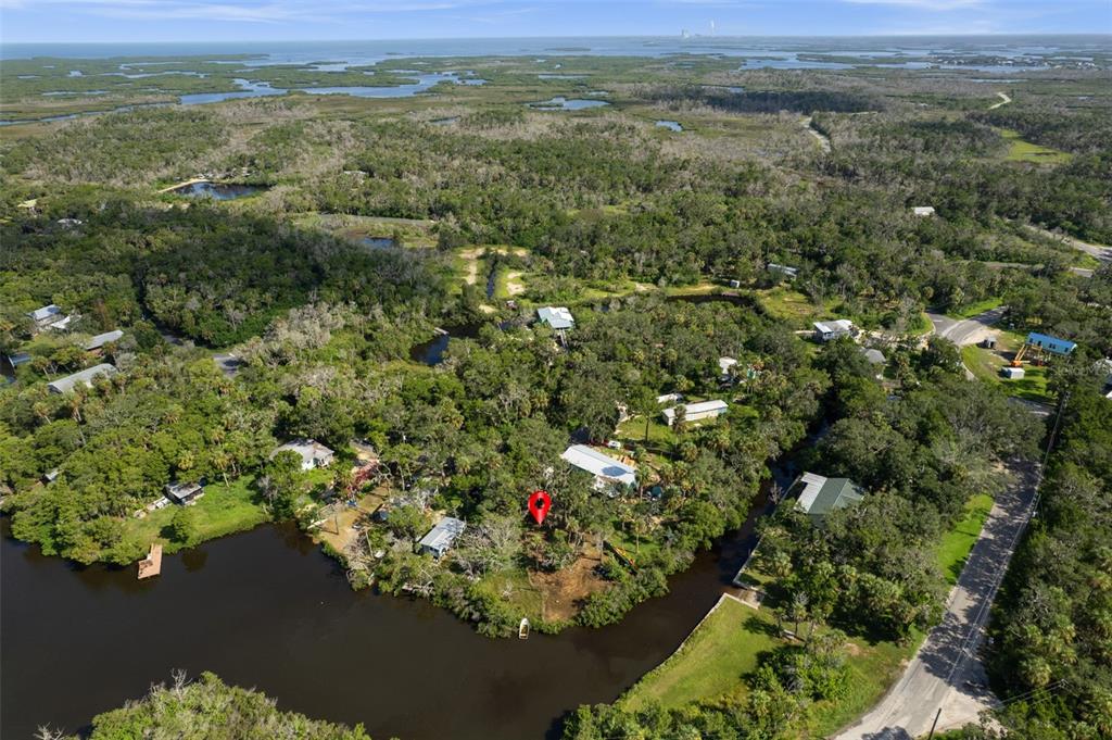 An aerial view of a waterfront property with a red location pin and surrounding trees — 14512 W BLACK CREEK DRIVE, CRYSTAL RIVER, FL