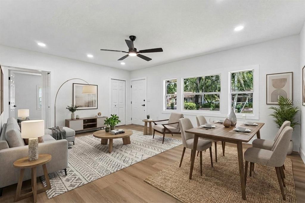 An open-concept living and dining room with light wood floors, white walls, and modern furniture — 1910 CURRY FORD ROAD, ORLANDO, FL