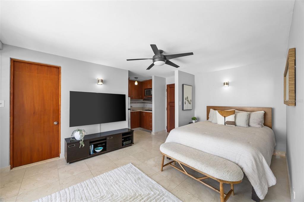 A studio apartment featuring a bed, a television, and a small kitchen area — 1126 ASHFORD AVENUE UNIT 88, SAN JUAN, PR