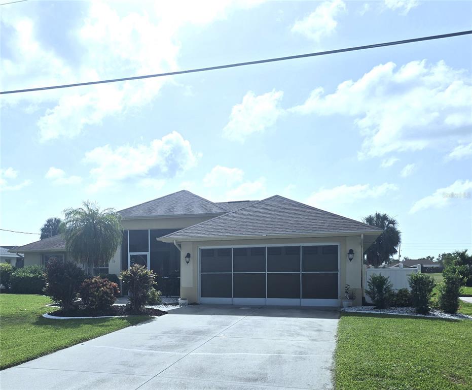 A detached garage with a brown roof and a multi-panel door sits on a lawn — 20 MEDALIST COURT, ROTONDA WEST, FL