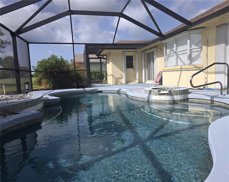 An aerial view of a single-story house with a tan exterior, tile roof, and driveway — 20 MEDALIST COURT, ROTONDA WEST, FL