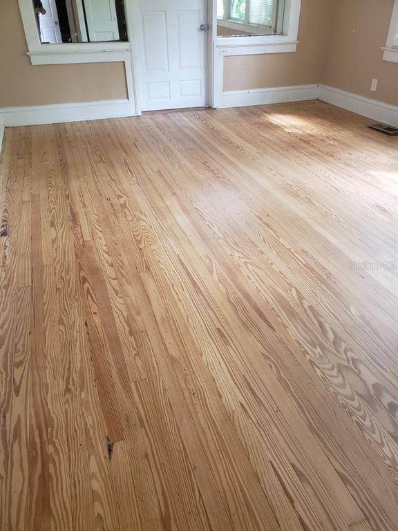 A room with light-colored, refinished hardwood floors, tan walls, and white trim — 724 N OLEANDER AVENUE, DAYTONA BEACH, FL