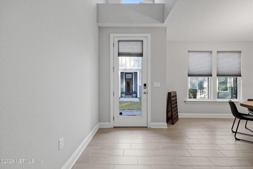 A bright entryway features light tile flooring, white walls, and a glass-paneled front door — 10023 FILAMENT BOULEVARD, JACKSONVILLE, FL