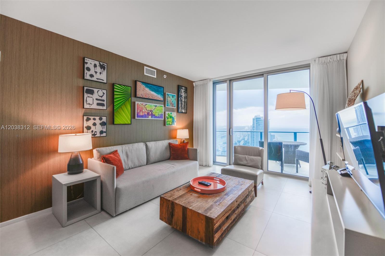 A living room features a grey sofa, wooden coffee table, and a balcony with ocean views — 4111 S Ocean Dr # 3204, Hollywood FL 33019, HOLLYWOOD, FL
