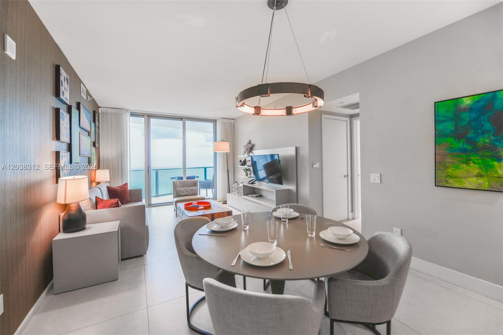 A modern dining area and living room feature a round table, ocean views, and artwork — 4111 S Ocean Dr # 3204, Hollywood FL 33019, HOLLYWOOD, FL