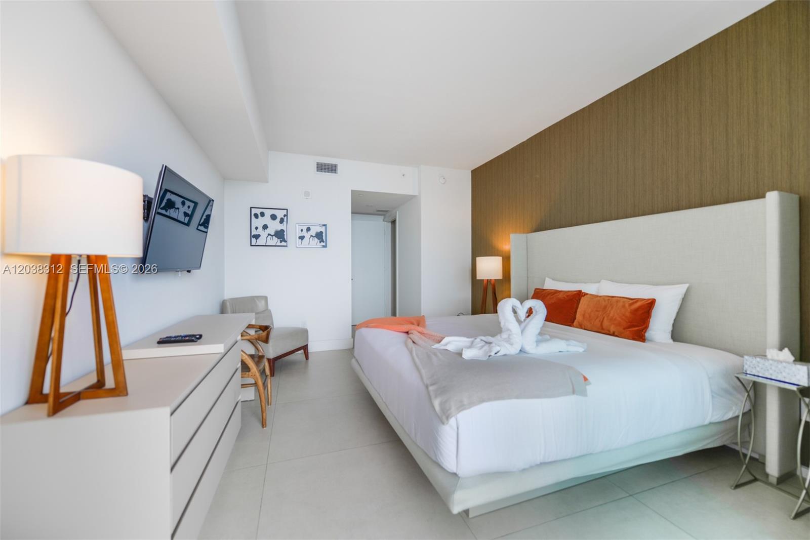A modern bedroom features a king bed with swan-shaped towels, a dresser, and tile flooring — 4111 S Ocean Dr # 3204, Hollywood FL 33019, HOLLYWOOD, FL