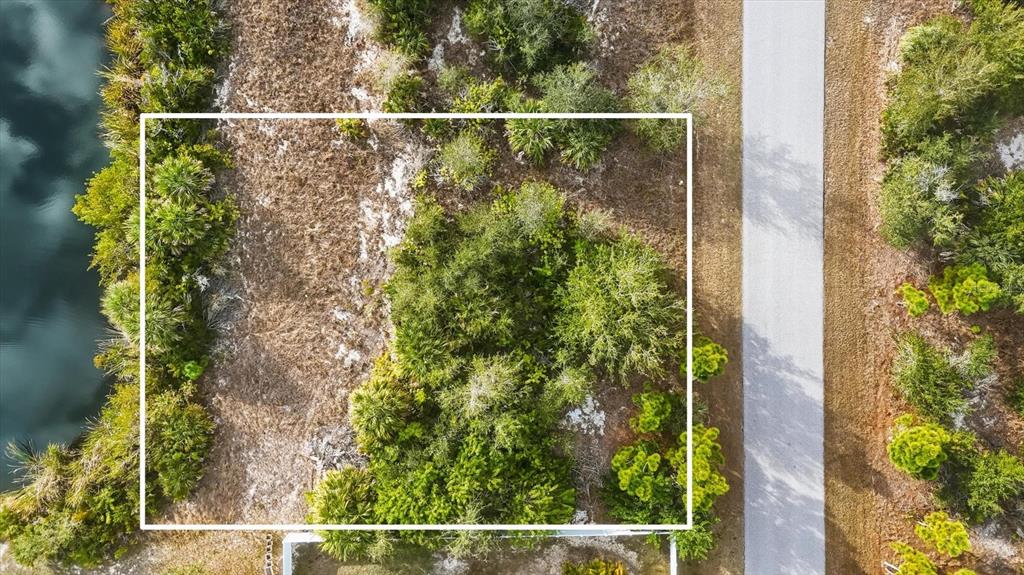 An aerial view shows a rectangular plot of land with vegetation next to a road — 9484 NASTRAND CIRCLE, PORT CHARLOTTE, FL