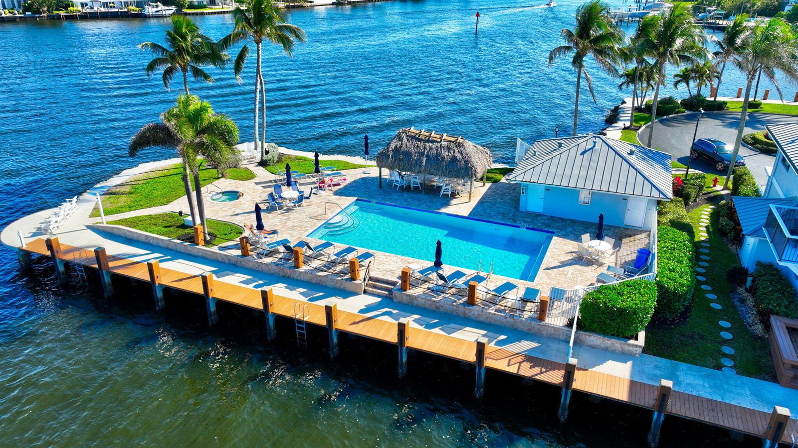 An aerial view of a waterfront swimming pool, tiki hut, and wooden dock — 732 NE 12th Terrace # 6, Boynton Beach FL 33435, BOYNTON BEACH, FL