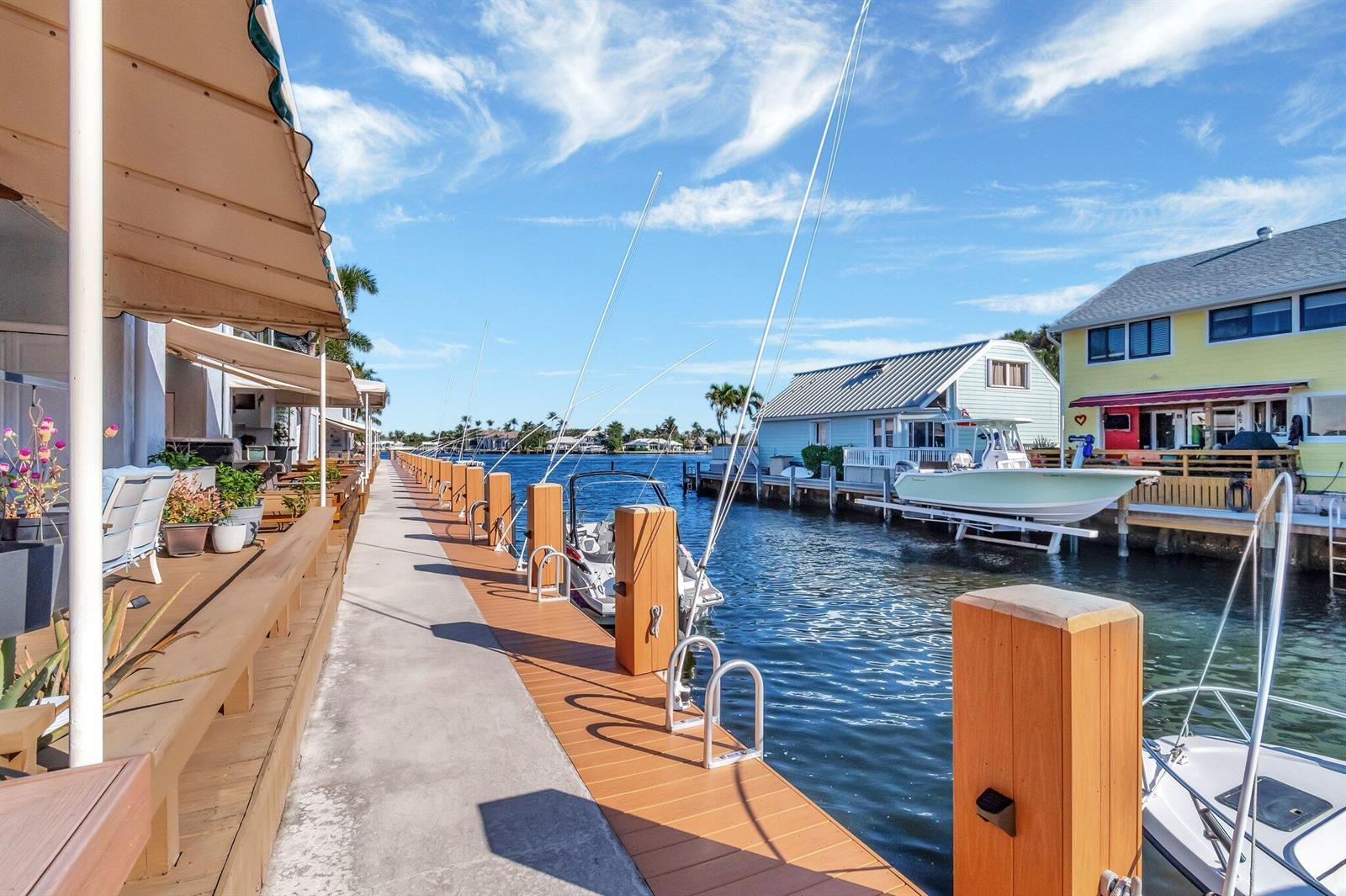 A concrete and wood dock runs alongside a canal with docked boats and waterfront homes — 732 NE 12th Terrace # 6, Boynton Beach FL 33435, BOYNTON BEACH, FL
