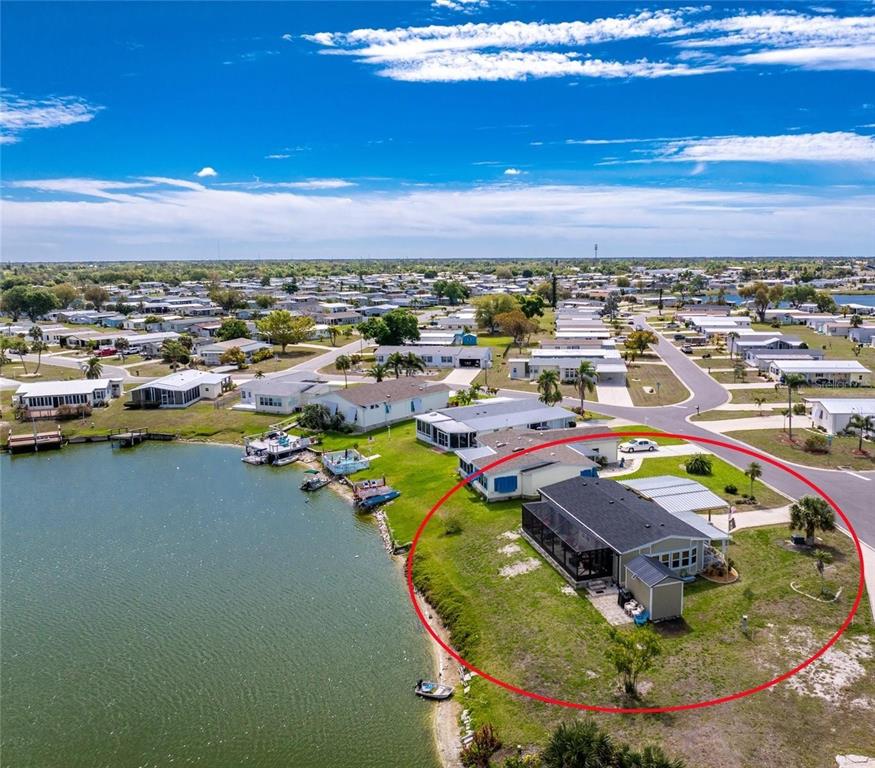 An aerial view shows a waterfront house with a screened porch and a small shed — 6115 SHEARWATER DRIVE, ENGLEWOOD, FL