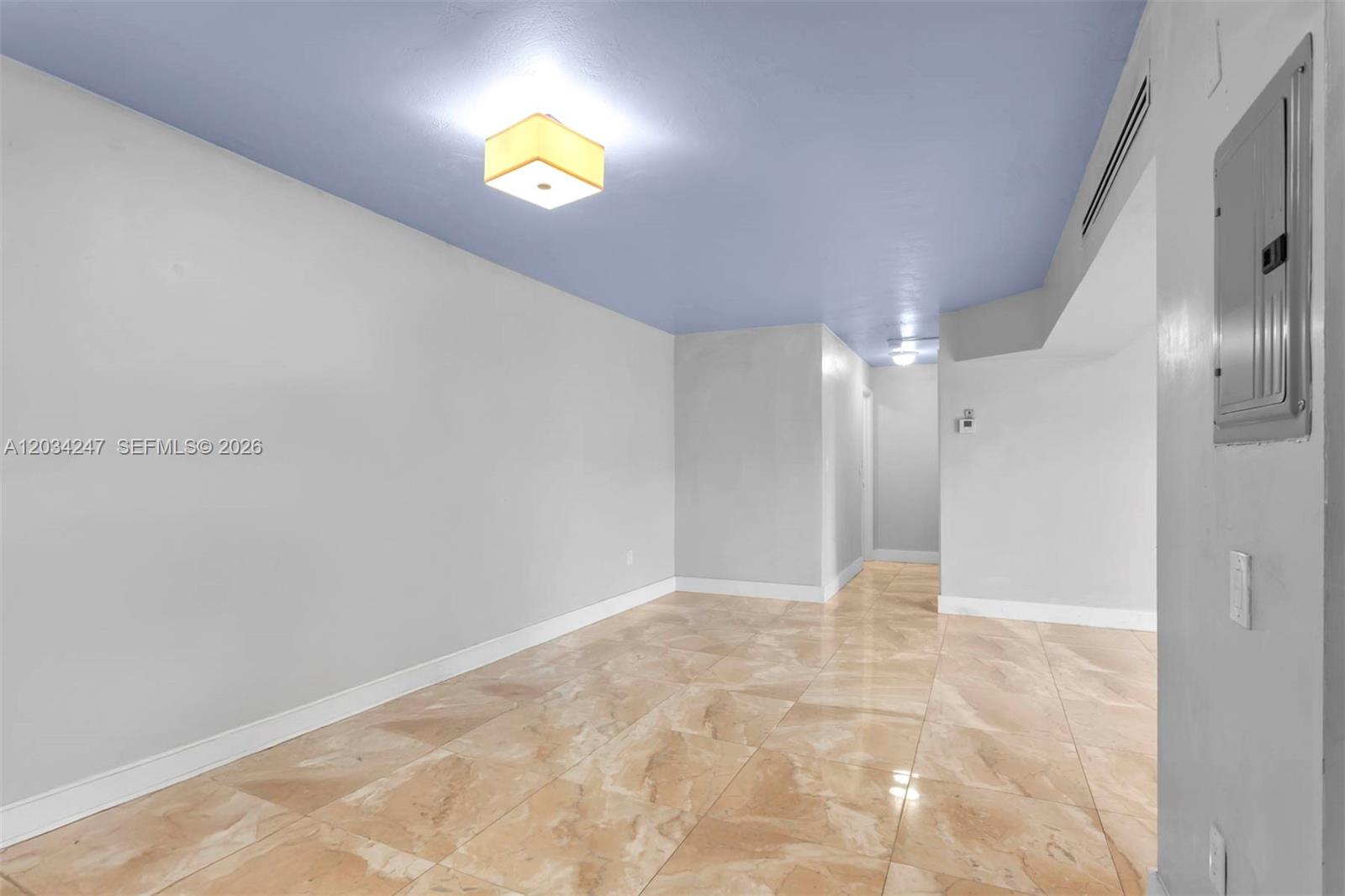 A room with light-colored walls, a blue ceiling, a square light fixture, and tiled flooring — 1820 James Ave # 2F, Miami Beach FL 33139, MIAMI BEACH, FL