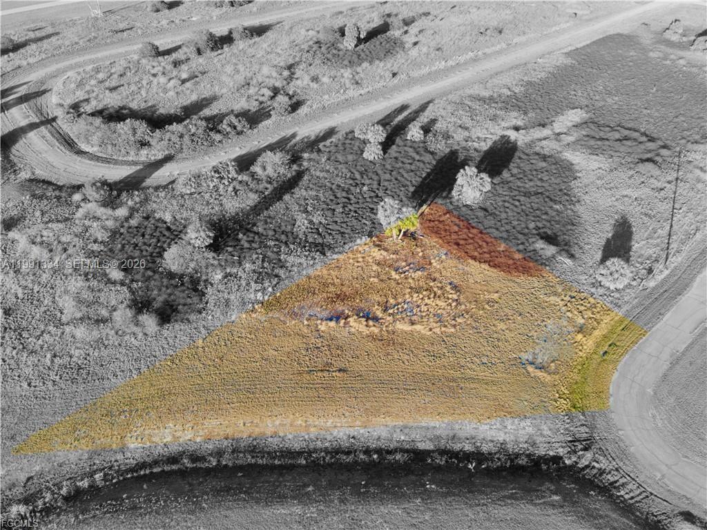 An aerial view shows a triangular plot of land bordered by a road and water — 216 LYNBROOK LOOP, La Belle FL 33935, LA BELLE, FL