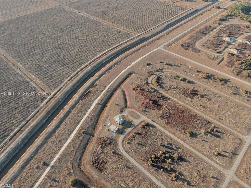 This aerial view shows a vacant lot outlined in red within a rural residential subdivision — 216 LYNBROOK LOOP, La Belle FL 33935, LA BELLE, FL