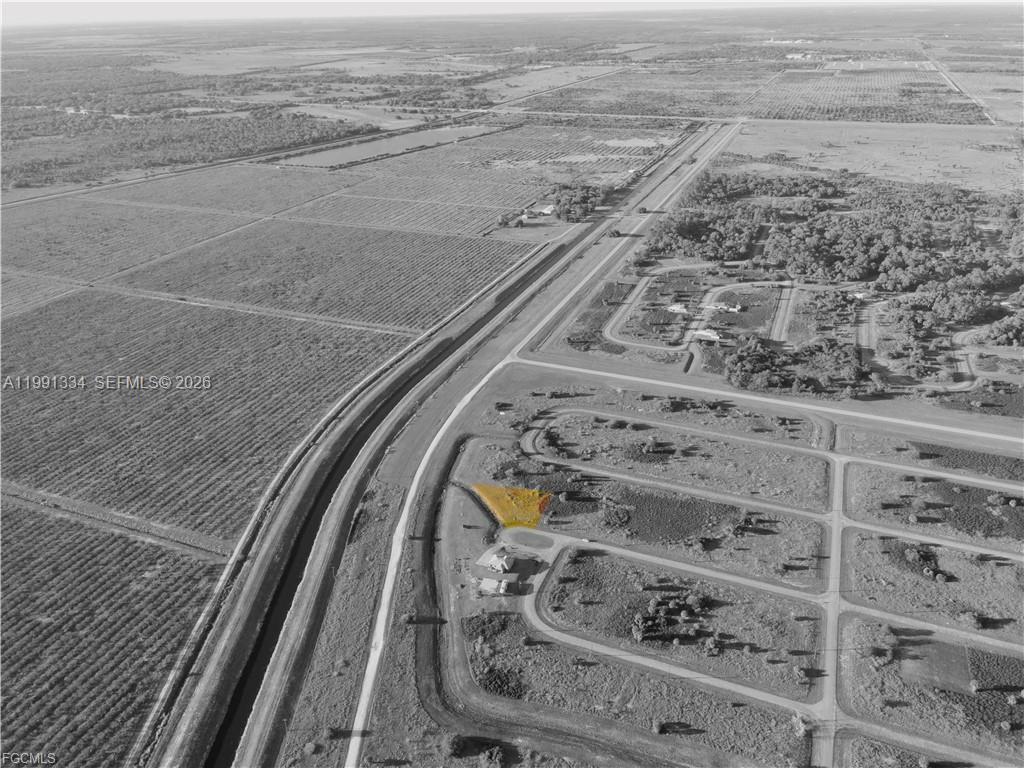 An aerial view shows a residential lot highlighted in yellow next to a canal — 216 LYNBROOK LOOP, La Belle FL 33935, LA BELLE, FL