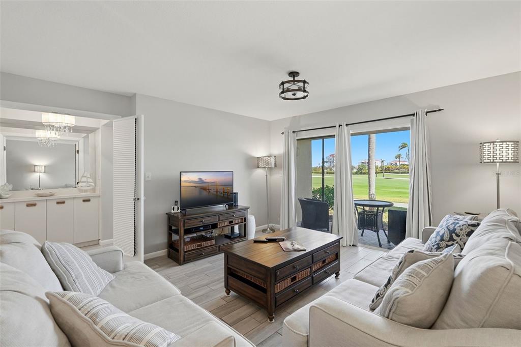 A living room features light gray walls, tile flooring, a coffee table, and a sliding door — 6151 BAHIA DEL MAR BOULEVARD UNIT 123, ST PETERSBURG, FL