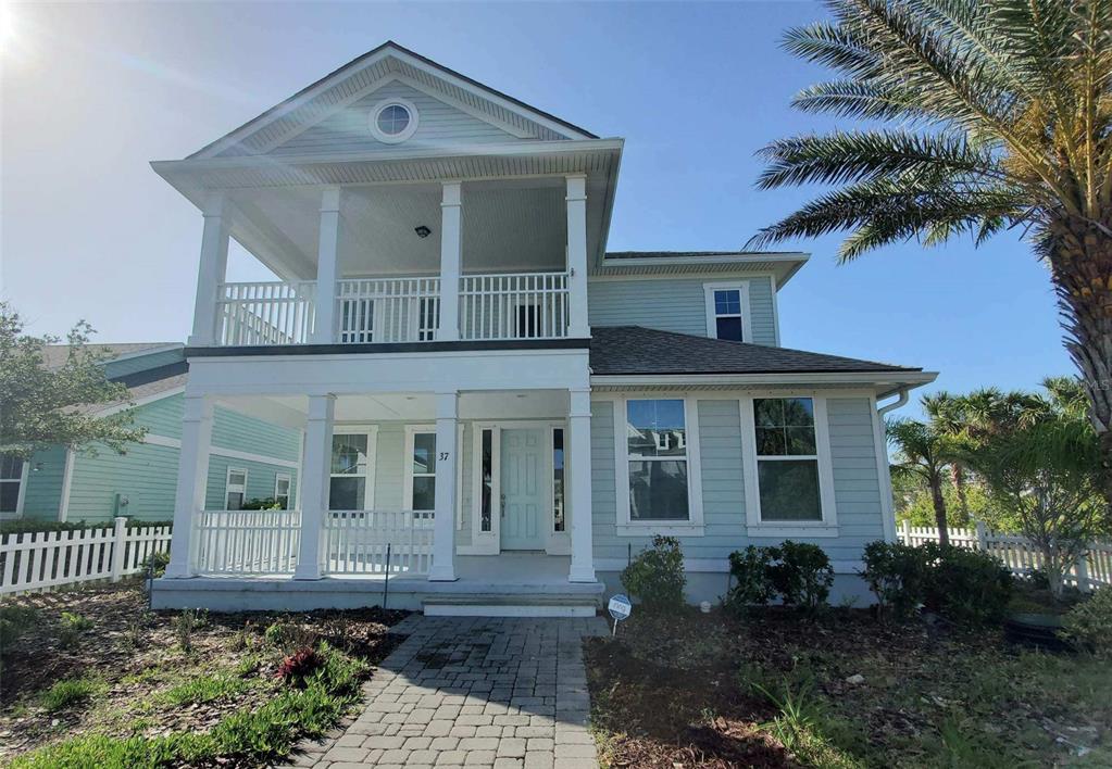 A two-story light blue house with a front porch and a second-floor balcony — 37 SANDY BEACH WAY, PALM COAST, FL