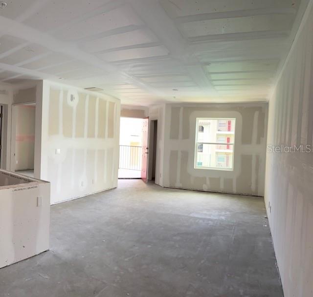 An unfinished room features drywall with taped seams, a concrete floor, and a window — 3024 PARKWAY BOULEVARD UNIT 204, KISSIMMEE, FL