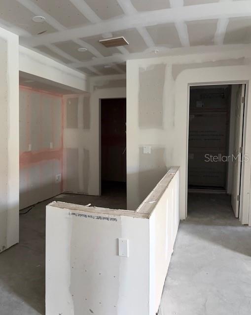 An interior view of a room under construction with unfinished drywall and exposed ceiling joists — 3024 PARKWAY BOULEVARD UNIT 204, KISSIMMEE, FL