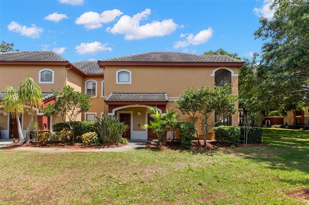 A rectangular swimming pool is surrounded by lounge chairs and palm trees at a complex — 2200 TUSCANY TRACE UNIT 15, PALM HARBOR, FL
