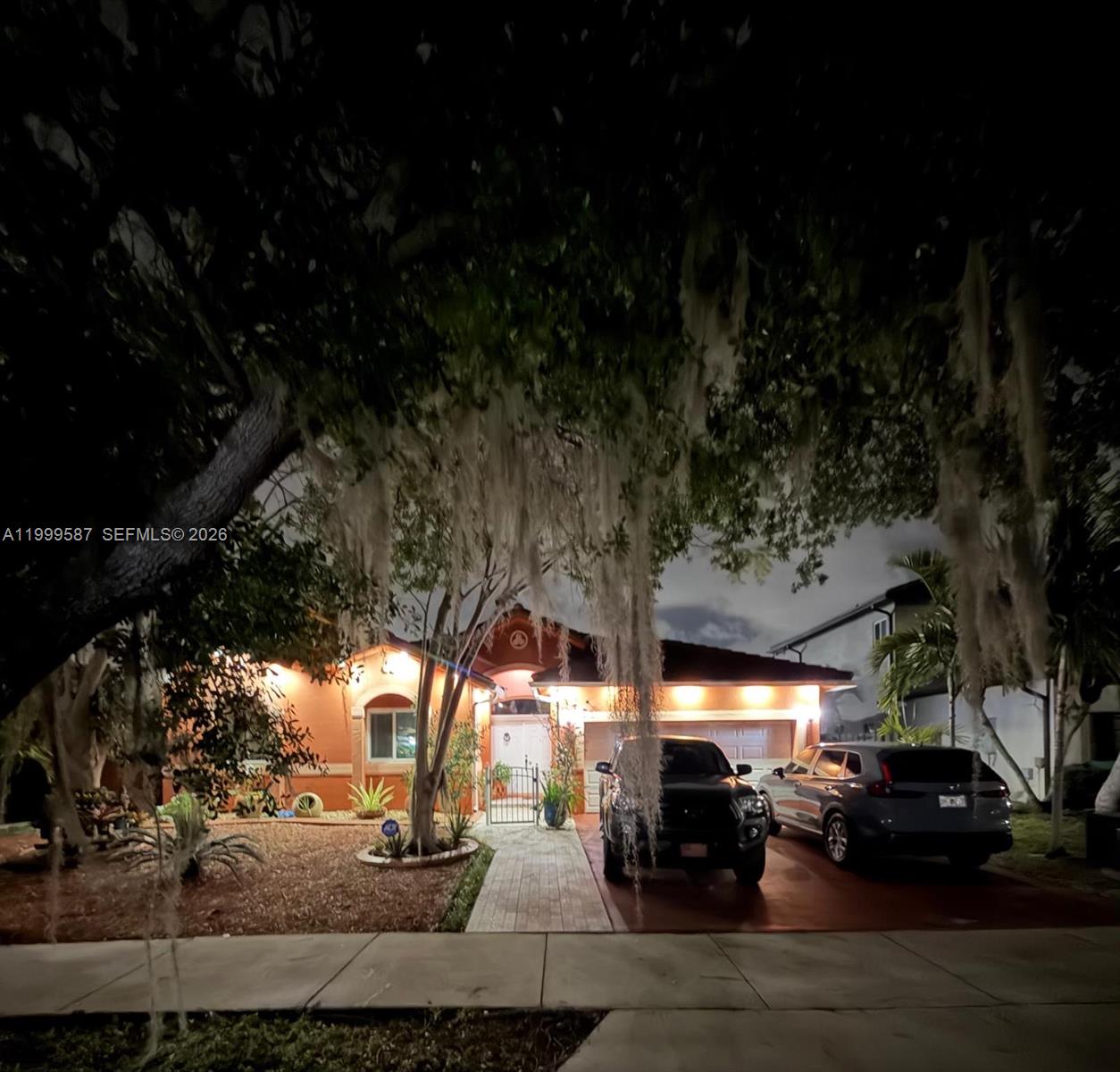 A single-story orange house with a tiled roof, a two-car garage, and a large tree — 14531 SW 160th Ct, Miami FL 33196, MIAMI, FL