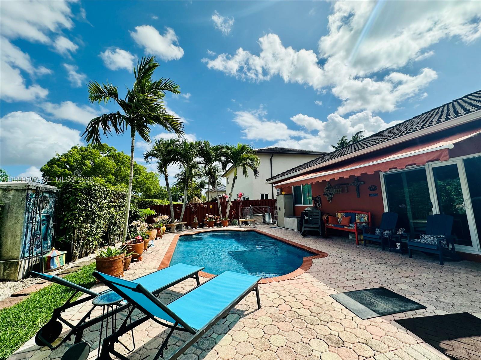 A house exterior features a patterned tile walkway leading to a gated front entrance — 14531 SW 160th Ct, Miami FL 33196, MIAMI, FL