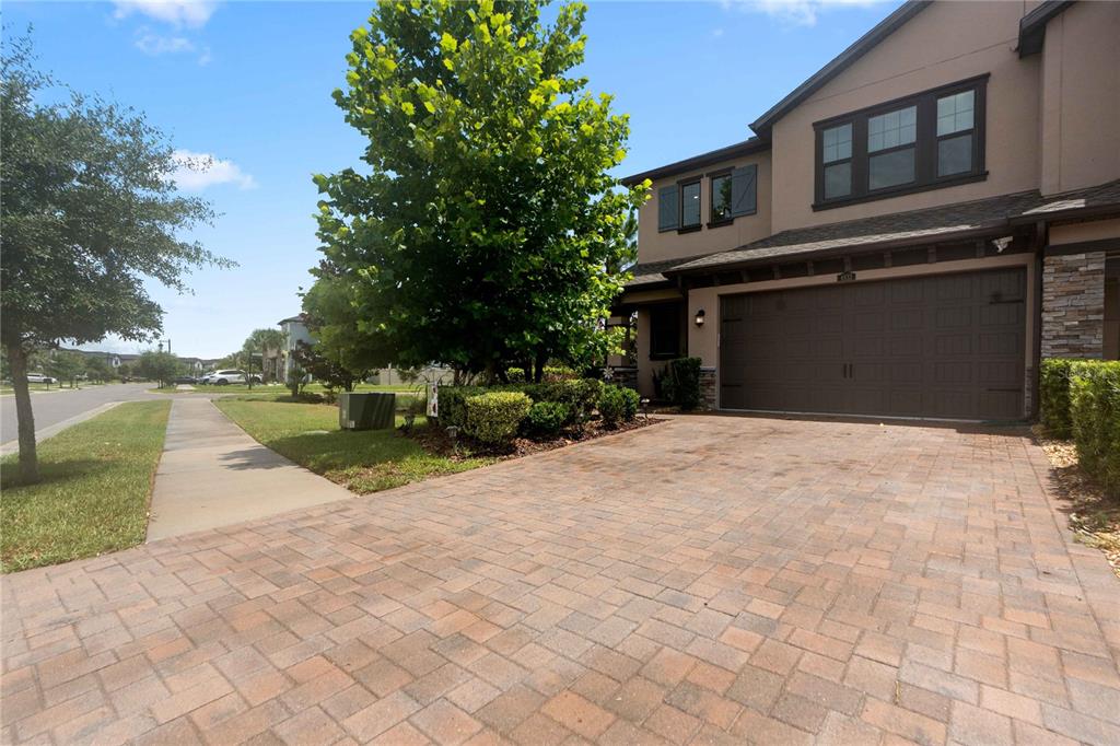A two-story house with a paved driveway, a garage, and a large tree in front — 4833 SAN MARTINO DRIVE, WESLEY CHAPEL, FL