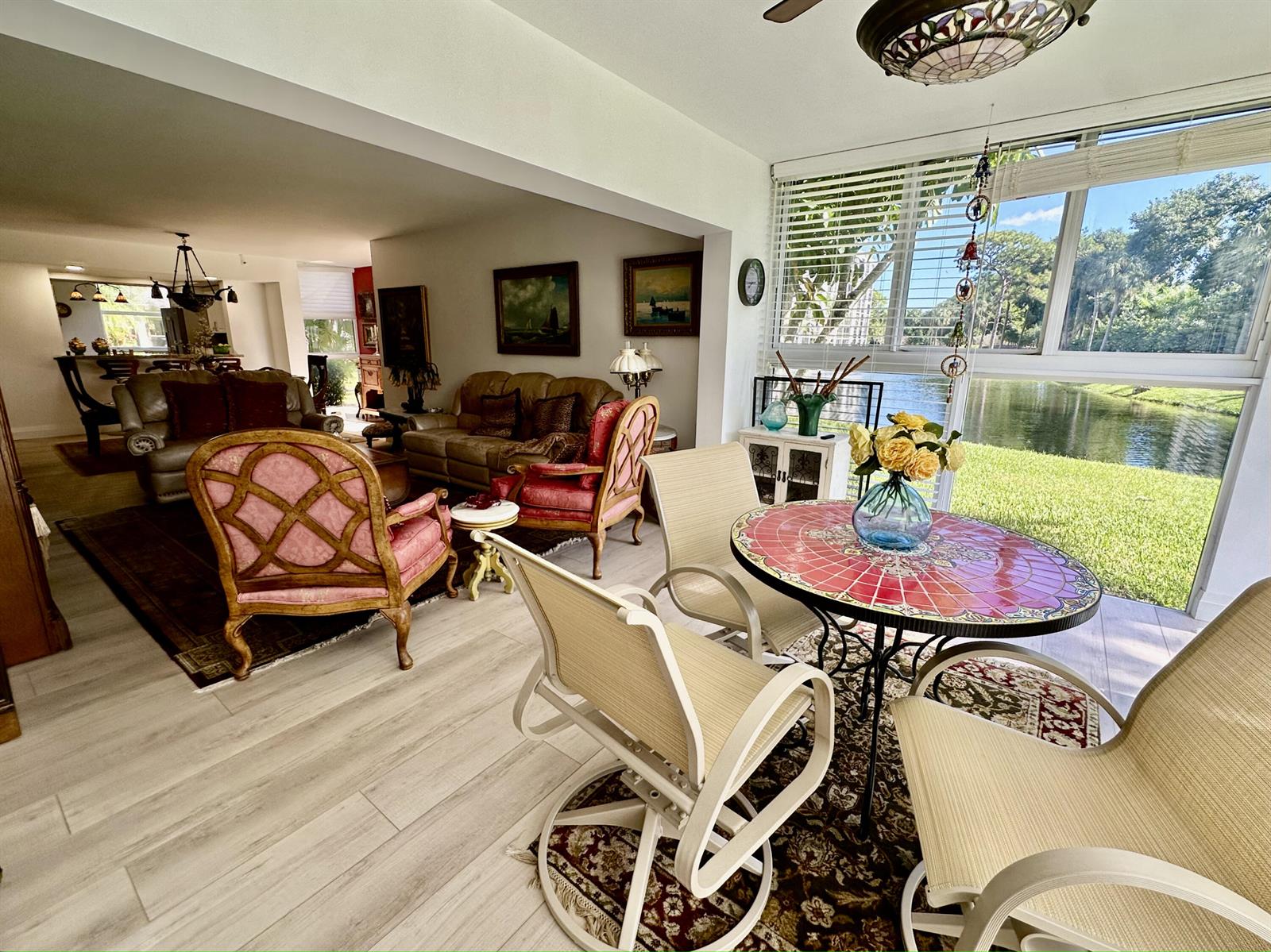 A sunroom with a mosaic table and chairs overlooks a lake through large windows — 6662 Boca Del Mar Drive # 111, Boca Raton FL 33433, BOCA RATON, FL