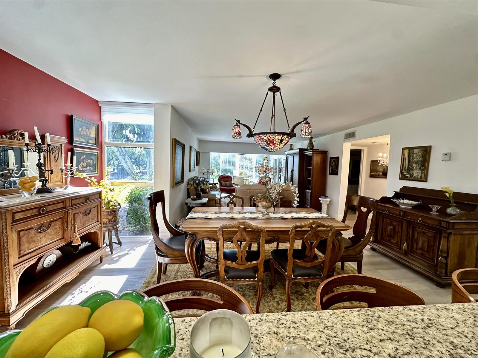 A dining room features a wooden table, ornate chairs, a stained-glass chandelier, and red accents — 6662 Boca Del Mar Drive # 111, Boca Raton FL 33433, BOCA RATON, FL