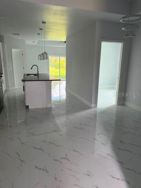 A kitchen with a dark island and pendant lights features white marble-look tile flooring — 744/746 EISENHOWER BOULEVARD, LEHIGH ACRES, FL