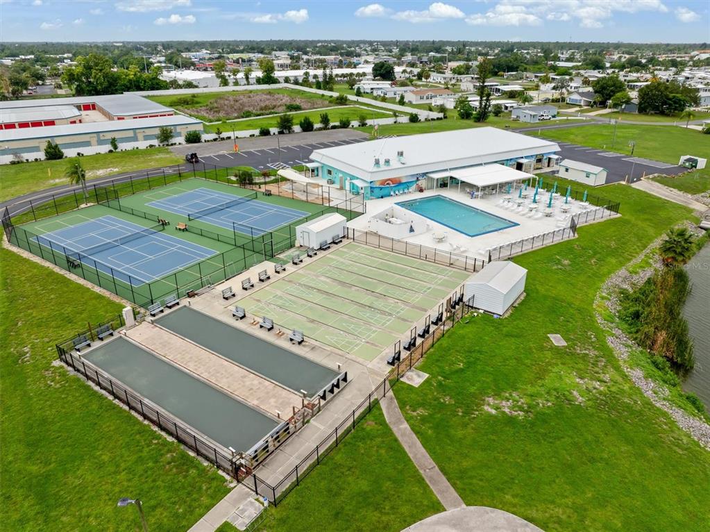 An aerial view shows a recreational area with tennis courts, shuffleboard courts, and a swimming pool — 6287 GREENFINCH ROAD, ENGLEWOOD, FL