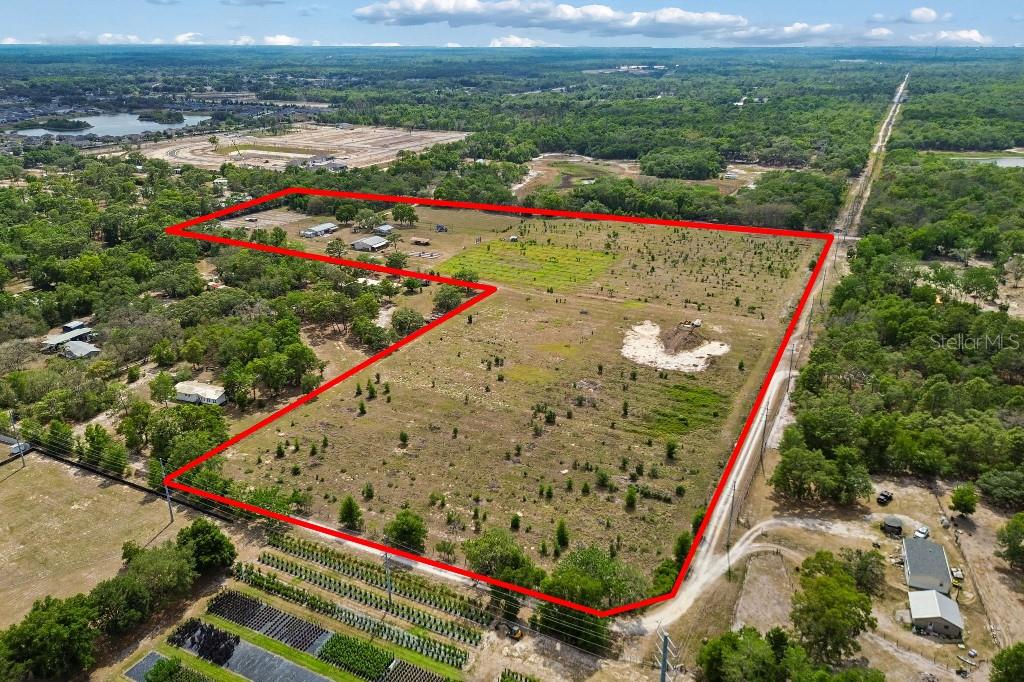 An aerial view shows a large, cleared plot of land outlined in red — 14320 FAMILY TRAIL, HUDSON, FL