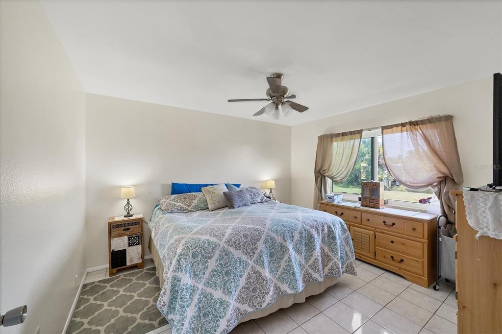 A living room features a blue patterned sofa, a rocking chair, and a cat tree — 9150 ARRID CIRCLE, PORT CHARLOTTE, FL