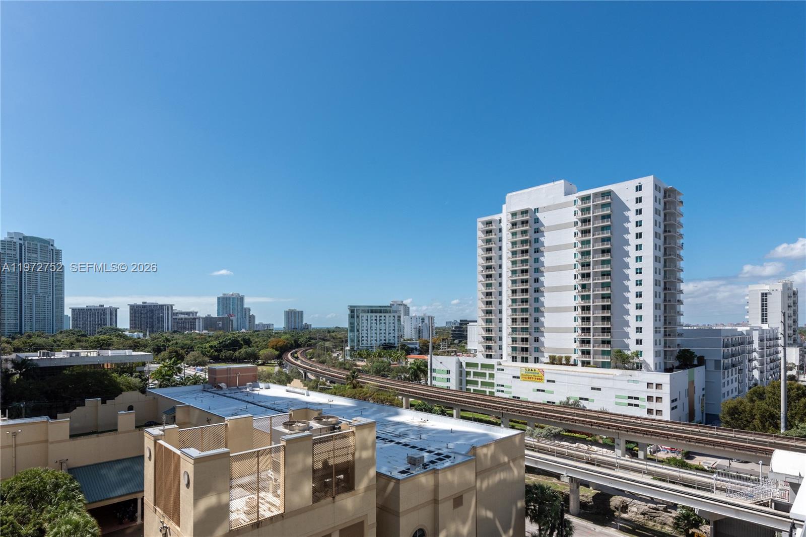 An elevated view shows a city skyline with a train track and apartment buildings — 79 SW 12th St, Miami FL 33130, MIAMI, FL