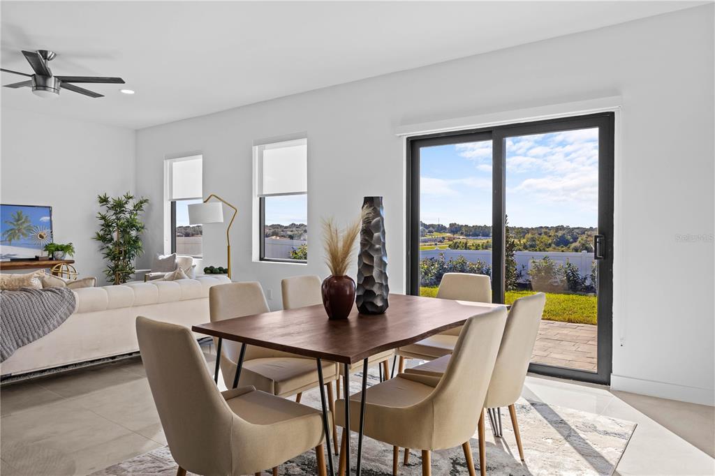 A dining area with a wooden table and chairs sits before a sliding glass door — 6440 QUARTET STREET, MASCOTTE, FL