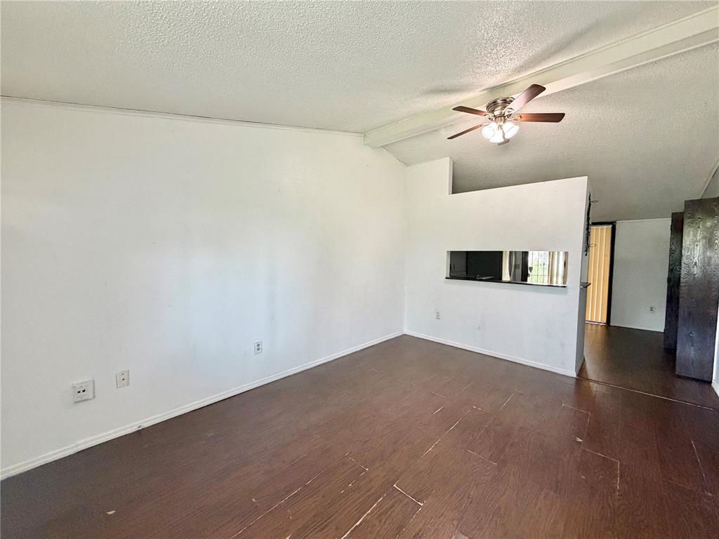 An empty room with white walls, dark wood-look flooring, and a ceiling fan — 1312 LAWNE BOULEVARD, ORLANDO, FL
