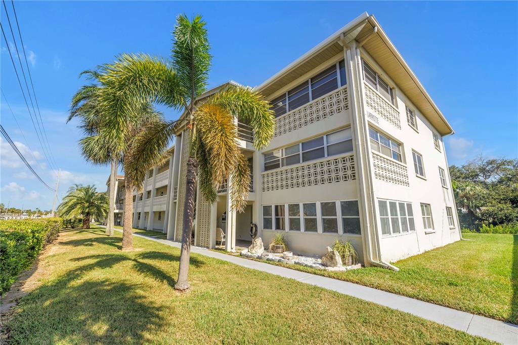 A three-story apartment building with a palm tree in the front yard — 4455 DUHME ROAD UNIT 109, ST PETERSBURG, FL