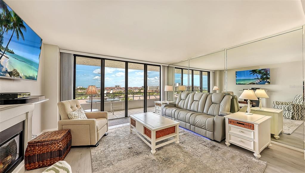 A living room features a light grey sofa, a coffee table, and a balcony with views — 6415 MIDNIGHT PASS ROAD UNIT 602, SARASOTA, FL